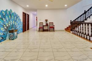 a hallway with a table and chairs and a painting on the wall at Collection O Calvathy Road Near Fort Kochi in Cochin