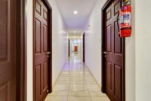 a hallway with two doors and a tile floor at Collection O Calvathy Road Near Fort Kochi in Cochin
