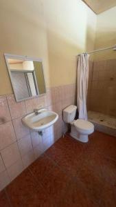 a bathroom with a sink and a toilet and a mirror at Accommodation in Copán Ruinas #7 in Copán Ruinas