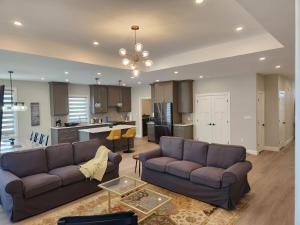 a living room with two couches and a kitchen at Prettiest town's lake- Bungalow in Goderich