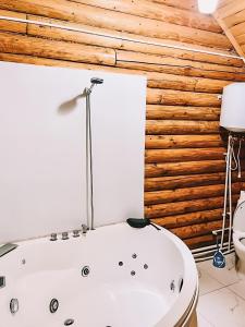 ein Badezimmer mit einer weißen Badewanne neben einer Toilette in der Unterkunft Hotel Riverwood in Machakhlispiri + 24 Fotos