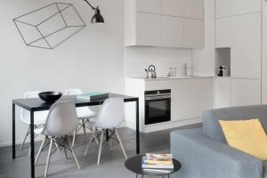 ミラノにあるBrera Apartments in Porta Ticineseのリビングルーム(テーブル、椅子付)、キッチン