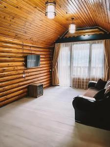 ein Wohnzimmer mit Sofa und Fernseher in der Unterkunft Hotel Riverwood in Machakhlispiri