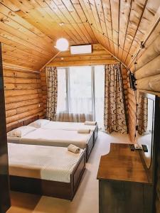 ein Schlafzimmer mit zwei Betten in einem Holzzimmer in der Unterkunft Hotel Riverwood in Machakhlispiri