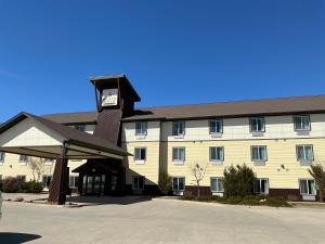 a large building with a clock tower in front of it at Black Gold Suites Tioga in Tioga