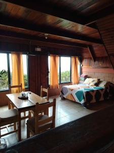 a bedroom with a bed and a table and chairs at Reserva Natural Cerro Alto in Empalme