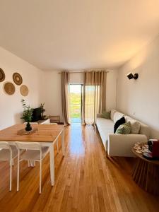 a living room with a table and a white couch at Horizonte da Vinha in Santo Tirso