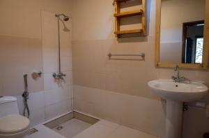 a bathroom with a sink and a toilet and a mirror at Moksha Resort Hunza in Chamangul