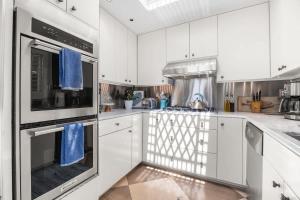 a kitchen with white cabinets and blue towels at Salty Sunrise in Aptos
