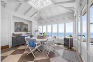 a dining room with a table and chairs and the ocean at Salty Sunrise in Aptos
