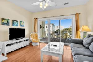 a living room with a couch and a tv at The Dunes by Oak Island Accommodations in Oak Island