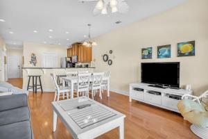 a living room with a couch and a tv and a table at The Dunes by Oak Island Accommodations in Oak Island
