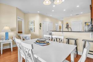 a kitchen and dining room with a white table and chairs at The Dunes by Oak Island Accommodations in Oak Island +41 photos
