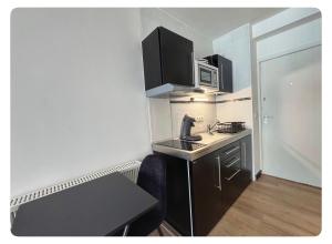 a small kitchen with a sink and a microwave at Studio Palace 217 in Middelkerke