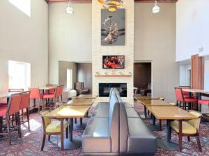 a dining room with tables and chairs and a fireplace at Black Gold Suites Tioga in Tioga