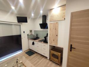 a kitchen with a stove and a large screen tv at logement indépendant proche des plages in Aimargues
