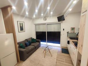 a living room with a couch and a kitchen at logement indépendant proche des plages in Aimargues