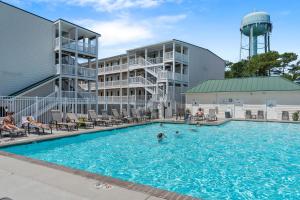 a pool at a hotel with people in the water at The Island Sandpiper by Oak Island Accommodations in Oak Island
