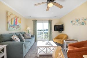 a living room with a couch and a tv at The Island Sandpiper by Oak Island Accommodations in Oak Island +53 photos