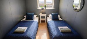 two beds in a small room with a mirror at Efra Sel Hostel in Fludir