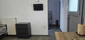 a room with a dresser and a tv on a wall at ΜaryAnn`s house 2 in Livadakia