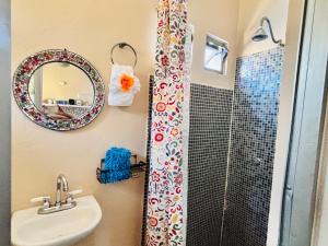 a bathroom with a sink and a shower with a mirror at Cozy Little Apartment in Sayulita