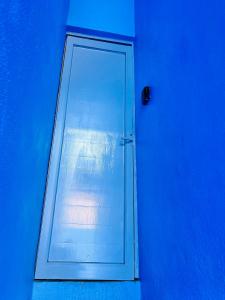 a door with a window in a blue room at Cozy Little Apartment in Sayulita