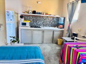 a room with a kitchen with a microwave and a table at Cozy Little Apartment in Sayulita