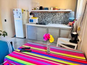 a vase with a flower on a table in a kitchen at Cozy Little Apartment in Sayulita +2 photos