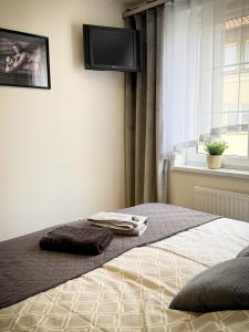 a bedroom with a bed with a flat screen tv on the wall at Apartament Orange Piastowska in Ostróda