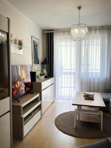 a living room with a tv and a table at Apartament Orange Piastowska in Ostróda