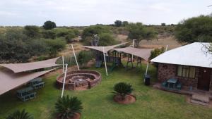 an aerial view of a house with umbrellas in a yard at Die Windpomp Bosveld in Ellisras
