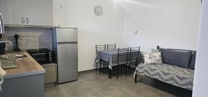 a kitchen with a table and a chair and a refrigerator at ΜaryAnn`s house 2 in Livadakia