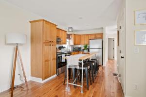 a kitchen with wooden cabinets and a kitchen island with stools at Newly Renovated Steps to Bars & Restaurants in Charleston