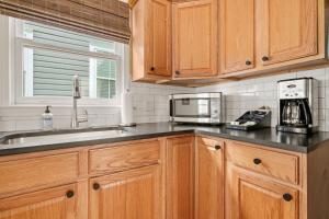 a kitchen with wooden cabinets and a microwave at Newly Renovated Steps to Bars & Restaurants in Charleston