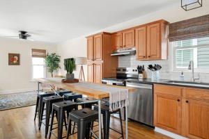 a kitchen with wooden cabinets and a wooden table with stools at Newly Renovated Steps to Bars & Restaurants in Charleston