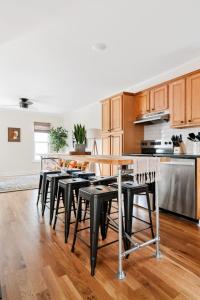 a kitchen with wooden cabinets and a table and chairs at Newly Renovated Steps to Bars & Restaurants in Charleston +21 photos
