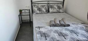 a bed with a black and white comforter and pillows at ΜaryAnn`s house 2 in Livadakia