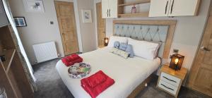 a bedroom with a large white bed with red pillows at The Key is Under the Mat in Polperro +15 photos