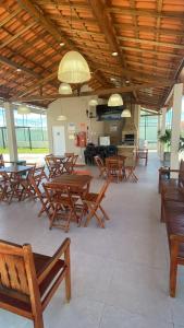 a room with wooden tables and wooden chairs at Casa Condomínio Reserva do Delta in Parnaíba