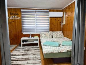 a small bedroom with a bed and a table at Studio 28 in Bajina Bašta