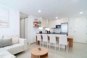 a white living room with a white couch and a kitchen at Nina da Nazare in Nazaré