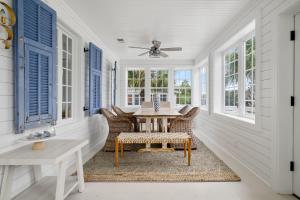 a dining room with a table and chairs and windows at Beach Bungalow Upper Unit Steps To Shore in Isle of Palms +33 photos