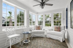 a living room with two chairs and a ceiling fan at Beach Bungalow Upper Unit Steps To Shore in Isle of Palms