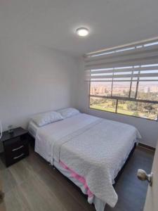 a bedroom with a bed and a large window at Penthouse Barú - Usaquén in Bogotá