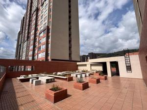 a patio with benches and potted plants on a building at Penthouse Barú - Usaquén in Bogotá
