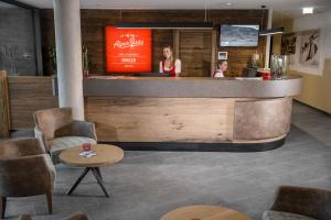 a woman standing at a counter in a restaurant at AlpenParks Hotel & Apartment Orgler Kaprun in Kaprun