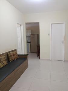 a living room with a couch and a kitchen at Apartamento Castelhanos Anchieta in Anchieta