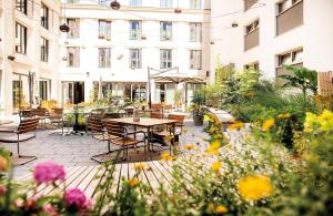 a patio with tables and chairs and flowers at Hilton Garden Inn Mannheim in Mannheim