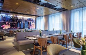 a restaurant with tables and chairs in a room at Hilton Garden Inn Mannheim in Mannheim